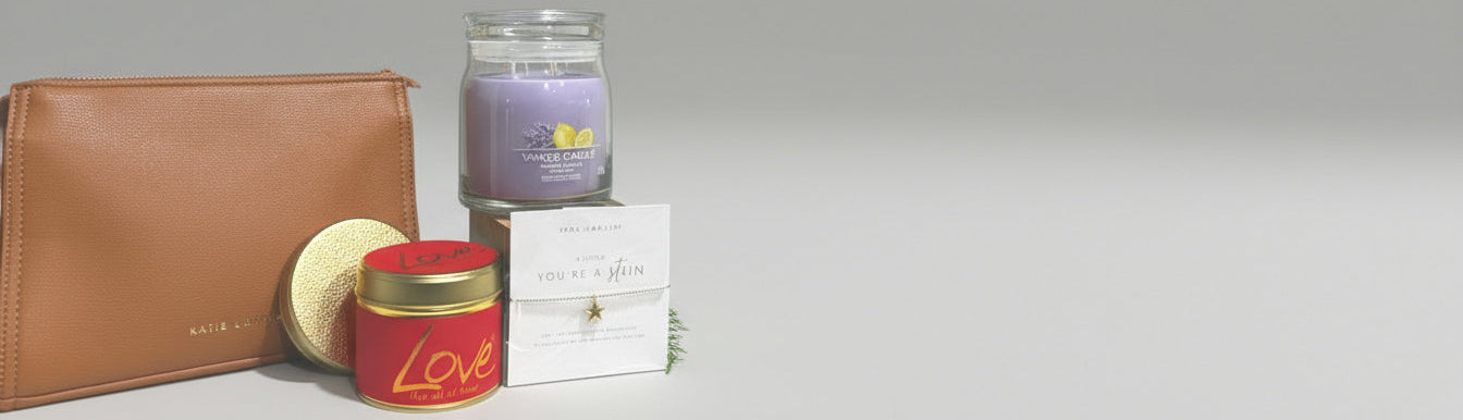 Candle, leather pouch, and decorative items on a wooden surface with a gray background